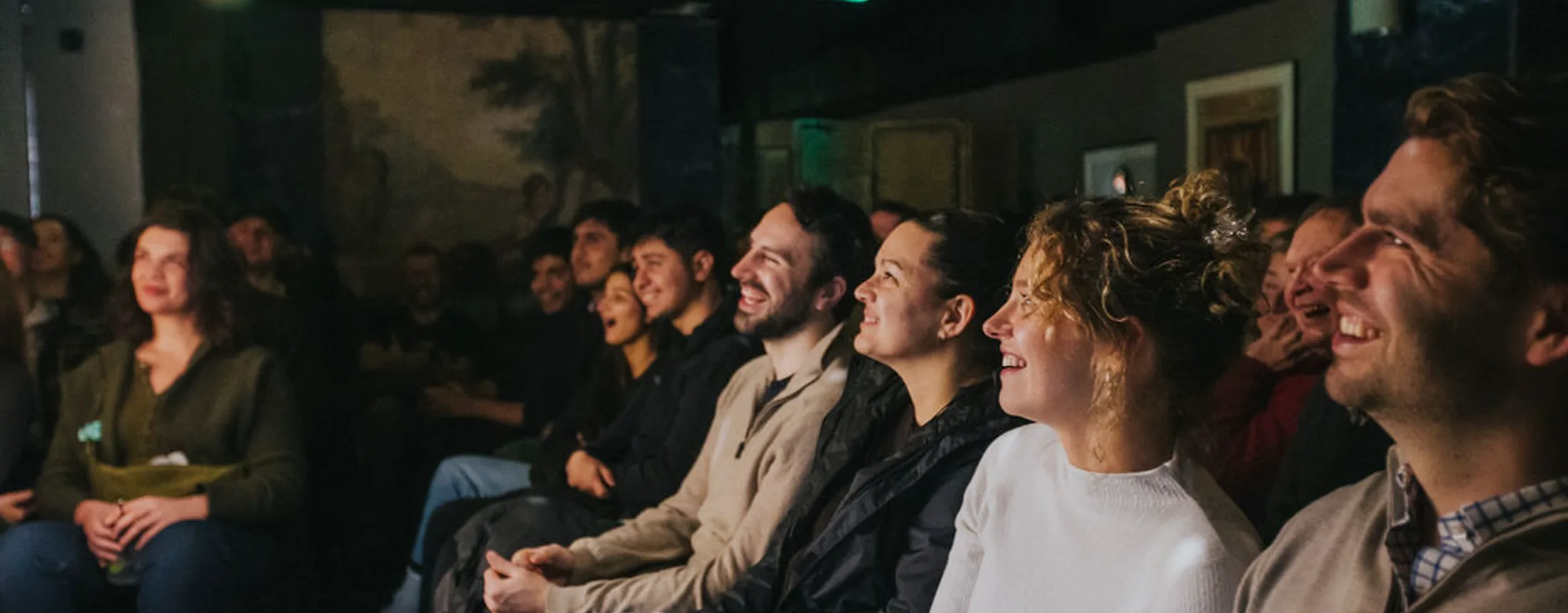 An audience laughing at a Soho Comedy Factory show